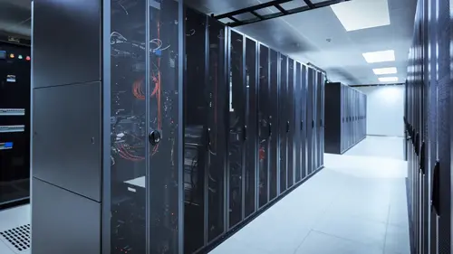 A modern data center aisle lined with tall server racks, featuring black cabinets with illuminated components, under bright ceiling lights.